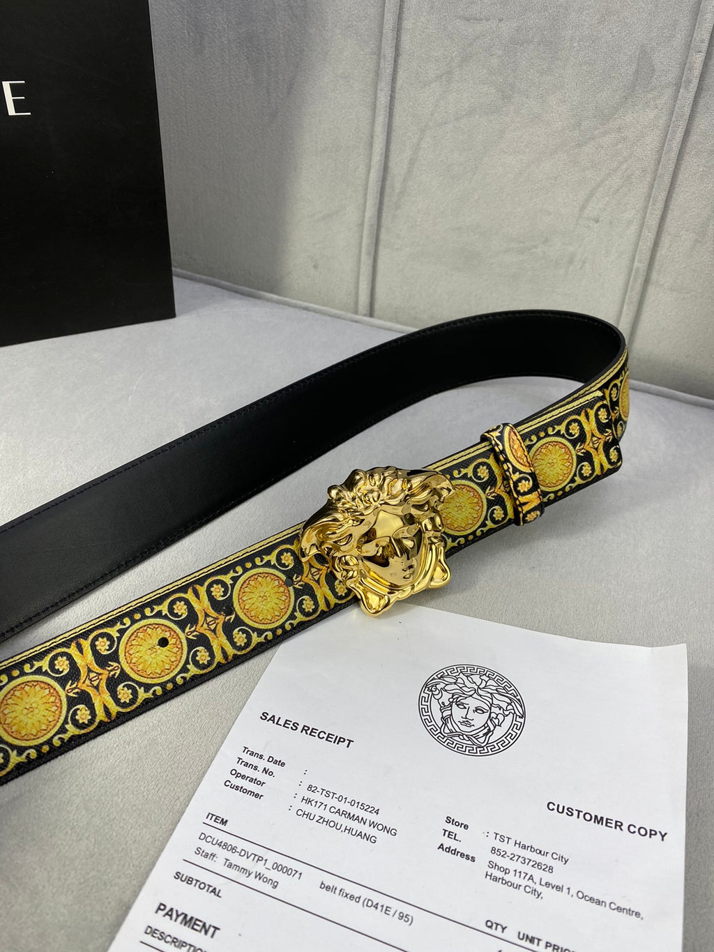 Designer belt side view: black strap with gold medallion trim and gold lion buckle