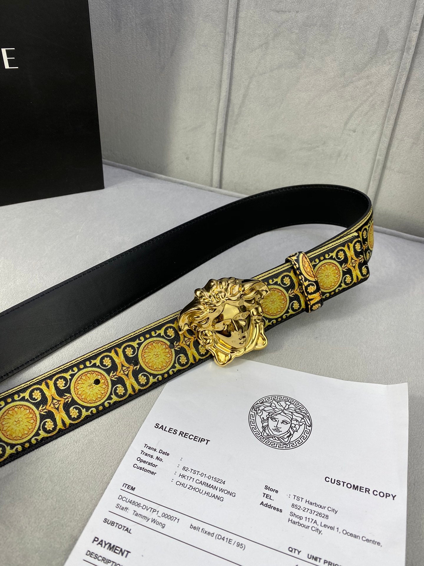 Designer belt side view: black strap with gold medallion trim and gold lion buckle