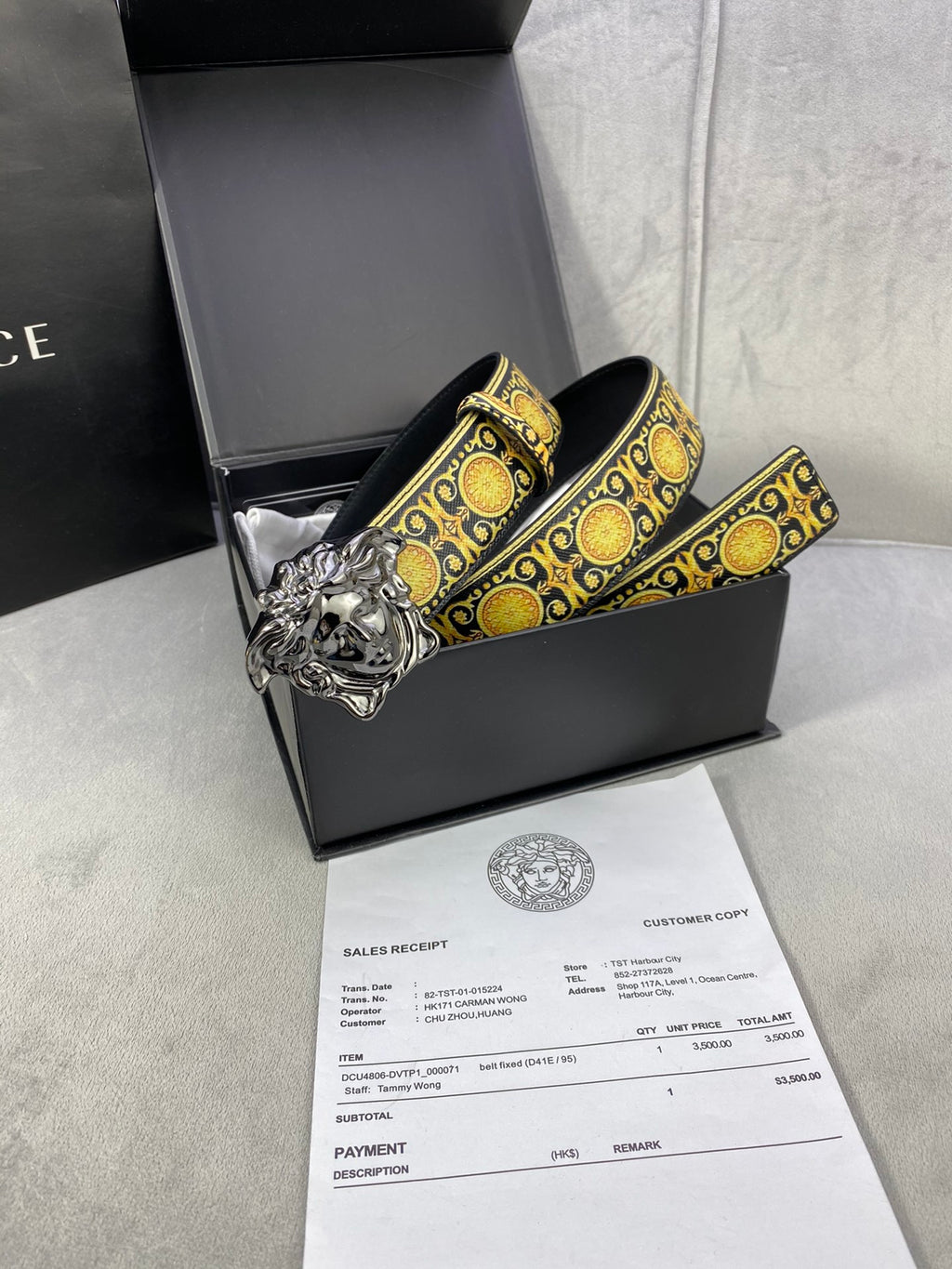 Designer belt coiled with gold medallion trim and oversized gold lion buckle