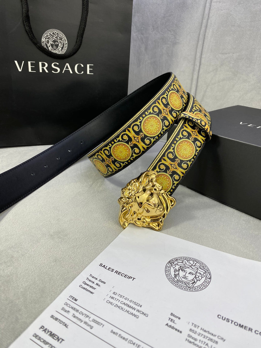 Designer belt with black strap, gold medallion trim, and ornate gold lion buckle