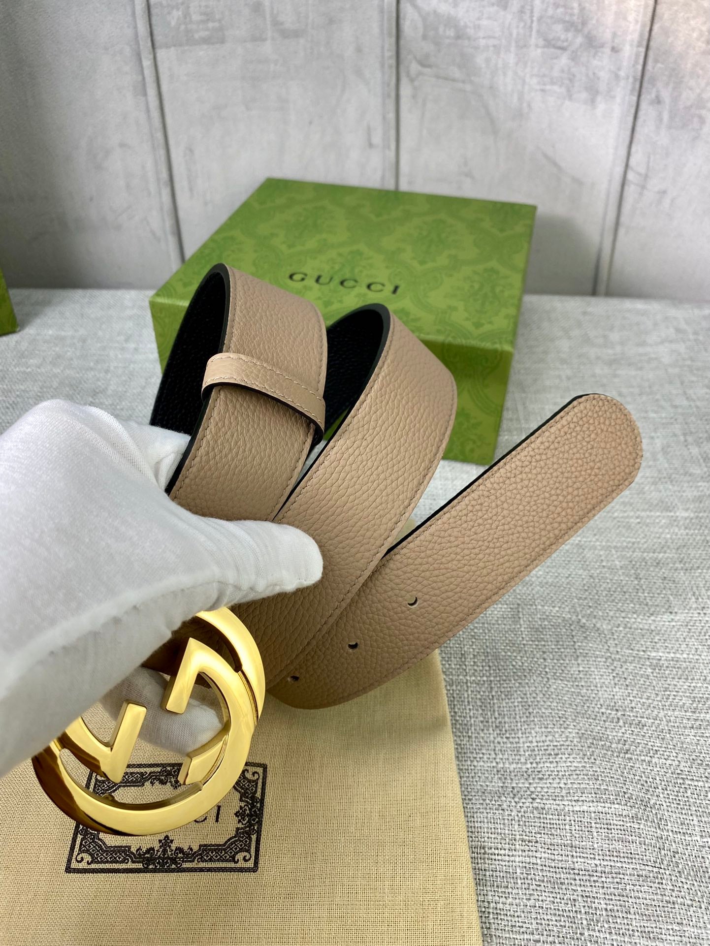 Gucci belt beige leather with gold double-G buckle, shown at an angled close-up