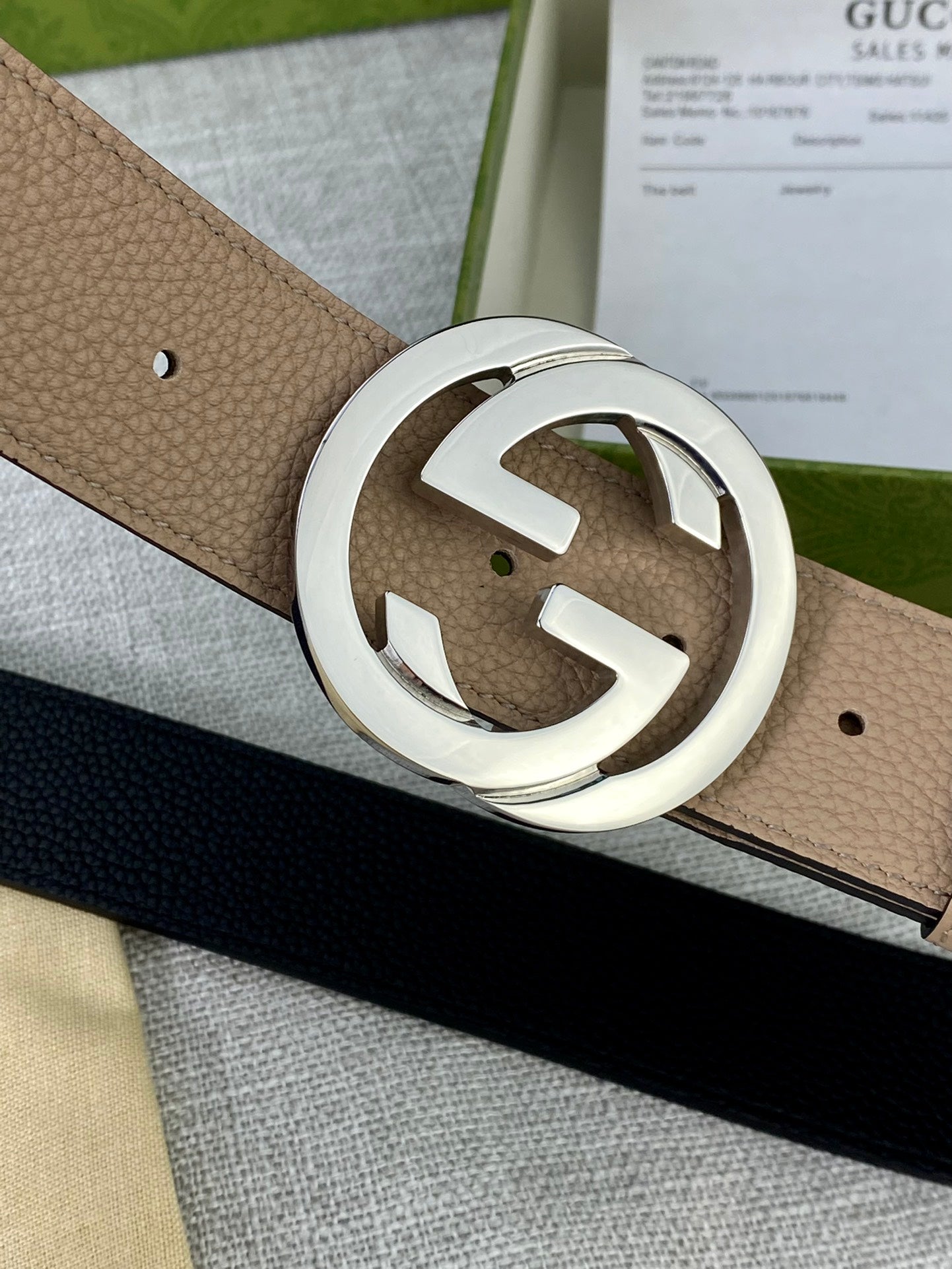 Gucci belt close-up of beige strap and silver double-G buckle with small holes