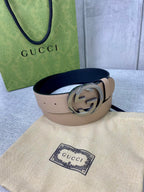 Gucci belt beige leather with silver double-G buckle, resting on a dust bag