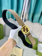 Gucci belt beige leather with gold double-G buckle and black underside, laid on fabric