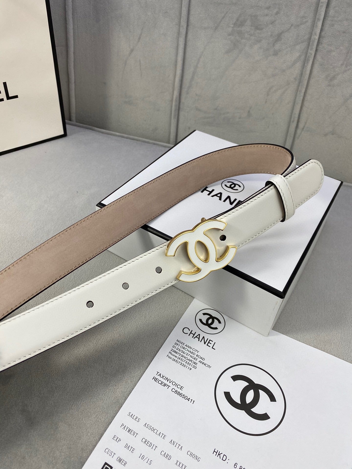 White leather belt with gold CC buckle and aligned adjustment holes