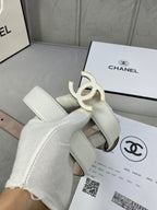 White leather belt with gold CC buckle, shown close-up