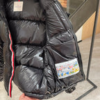 Moncler long puffer jacket side closeup, dark quilted fabric with logo patch