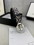 Gucci belt angled view: navy/beige GG strap with metallic interlocking G buckle