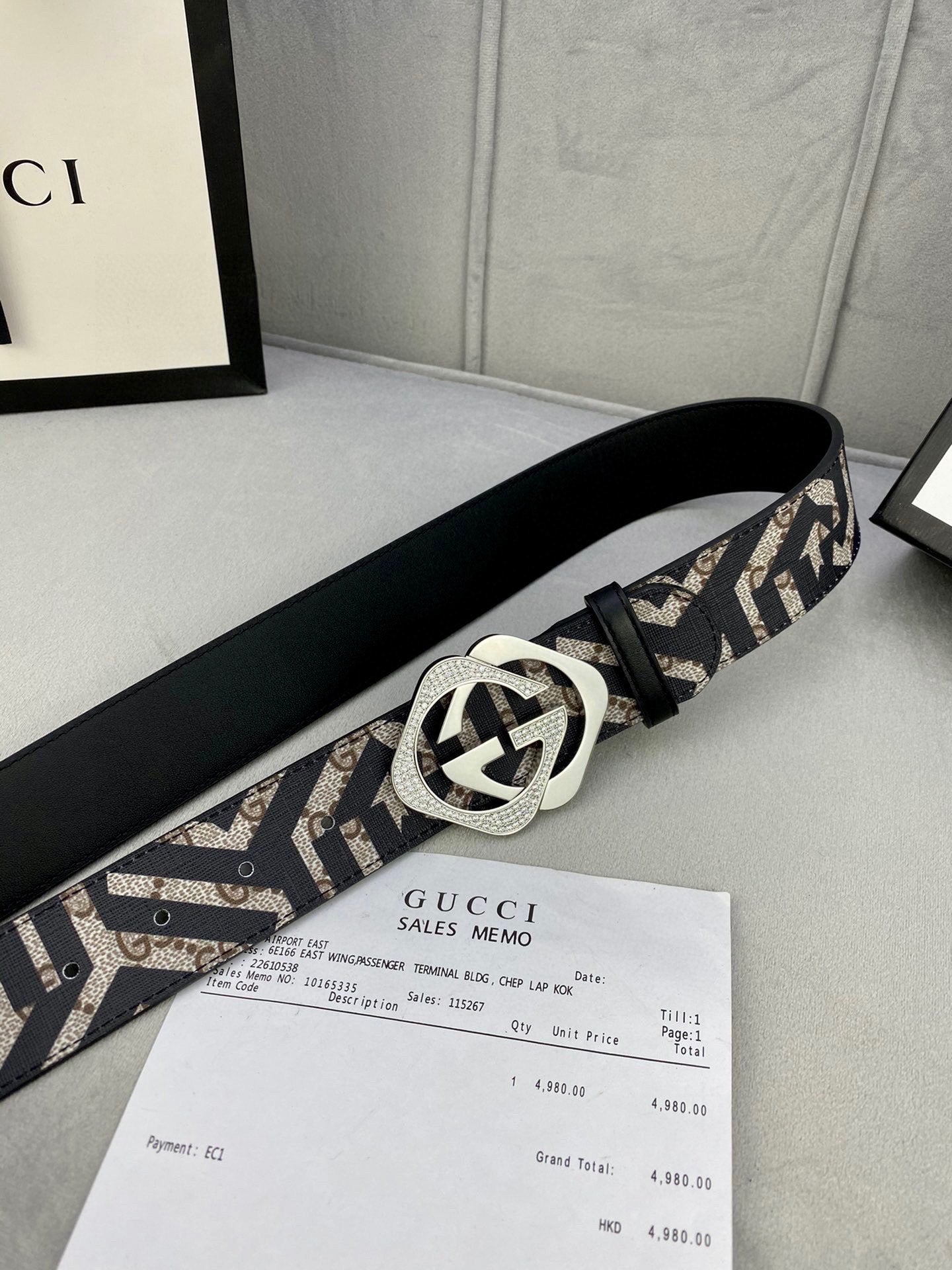 Gucci belt side view: goldtone interlocking G buckle on navy/beige GG strap