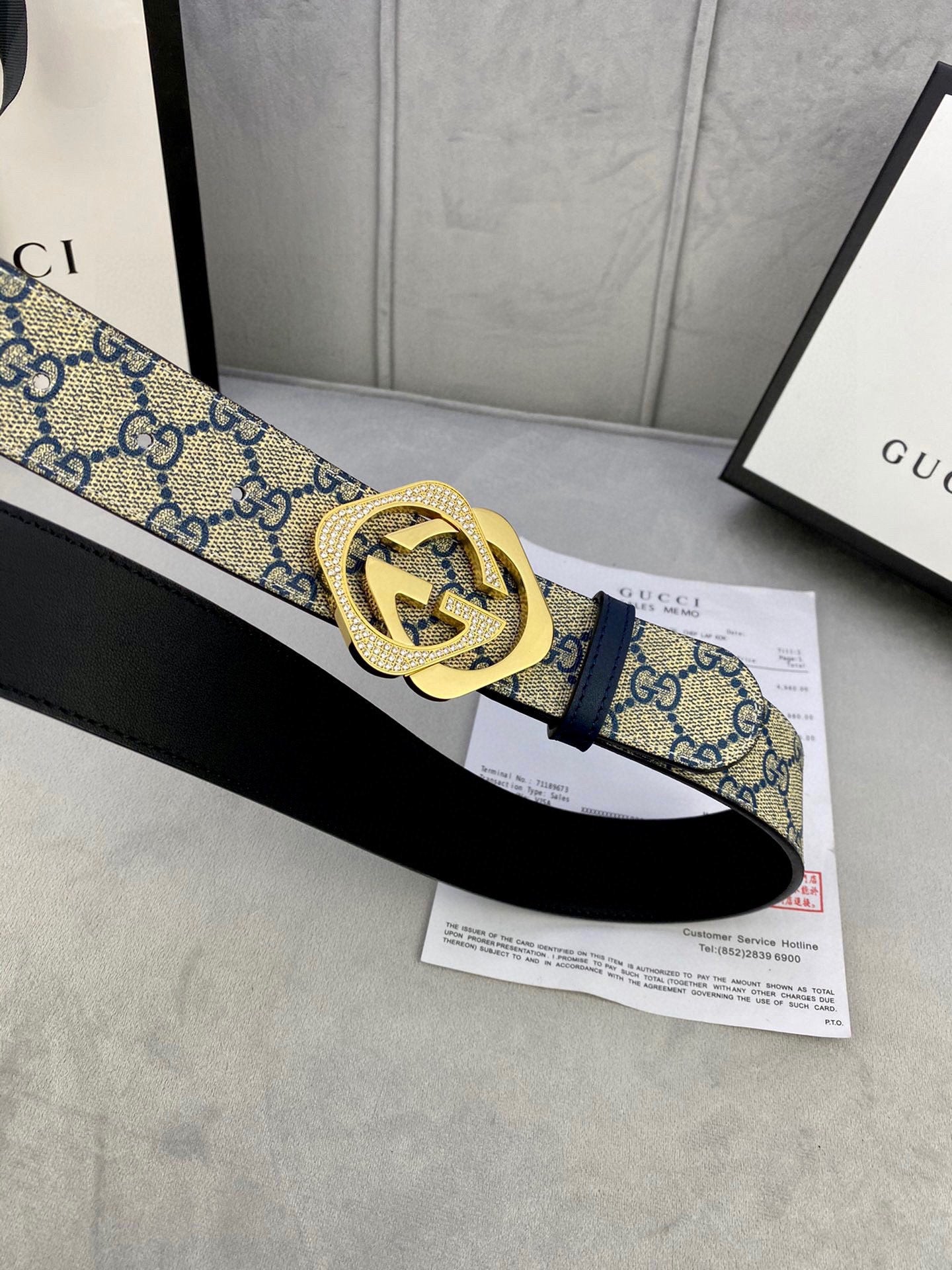 GG monogram belt with navy strap, gold-tone buckle, and black leather strap beneath