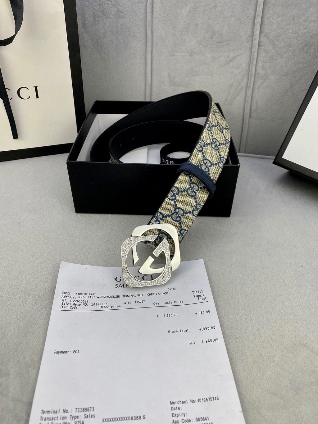 GG monogram belt with navy strap and gold-tone buckle, shown in a gift box