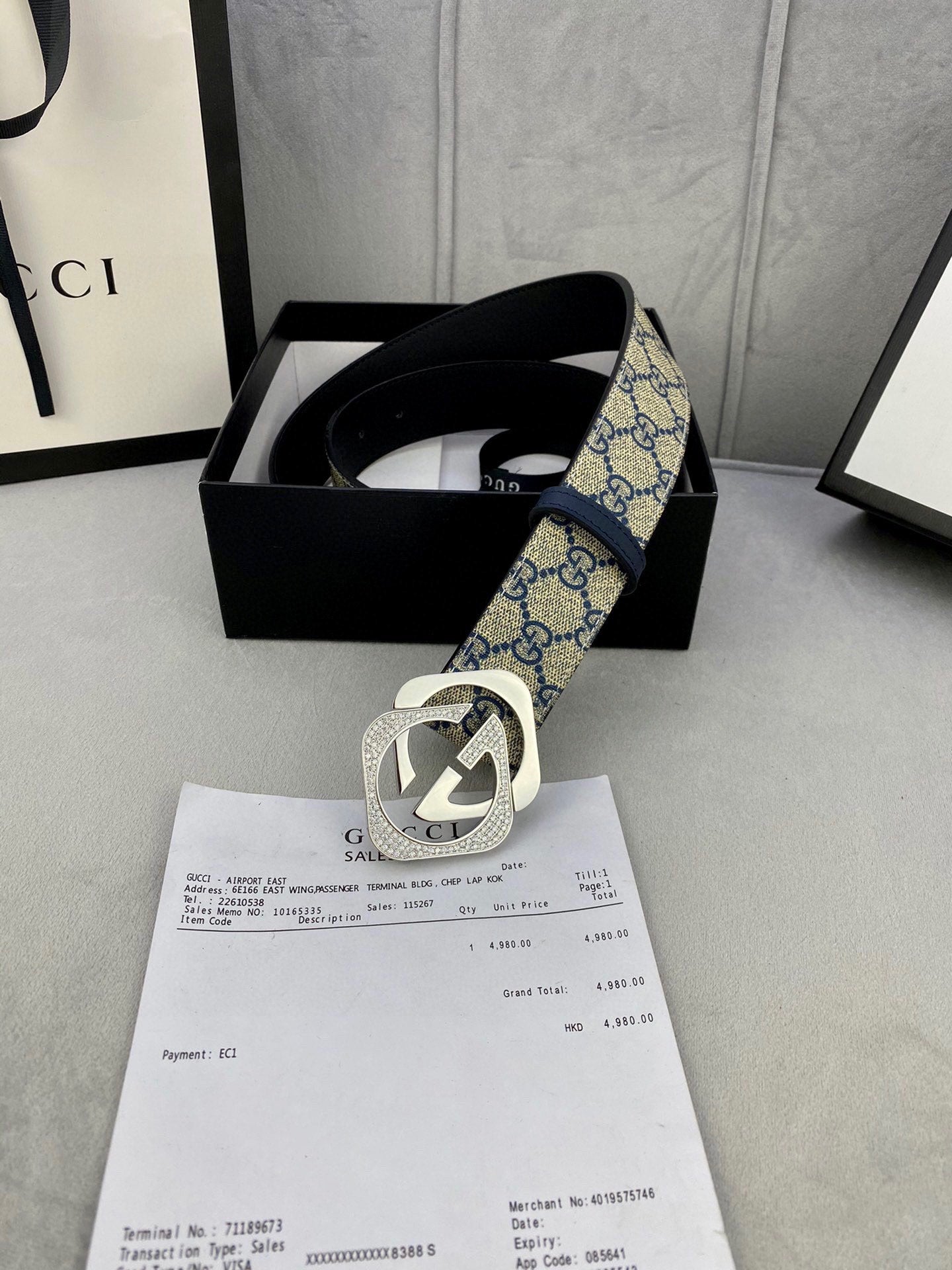 GG monogram belt with navy strap and gold-tone buckle, shown in a gift box