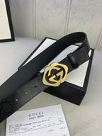 Gucci belt with dark leather strap and gold interlocking emblem buckle detail.
