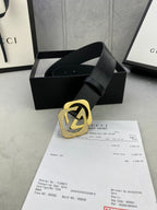 Gucci belt with dark leather strap and gold interlocking buckle, studded strap end.