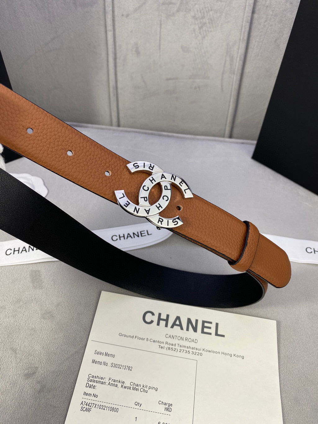 Chanel belt close-up: tan-brown leather with gold CHANEL buckle and punched holes