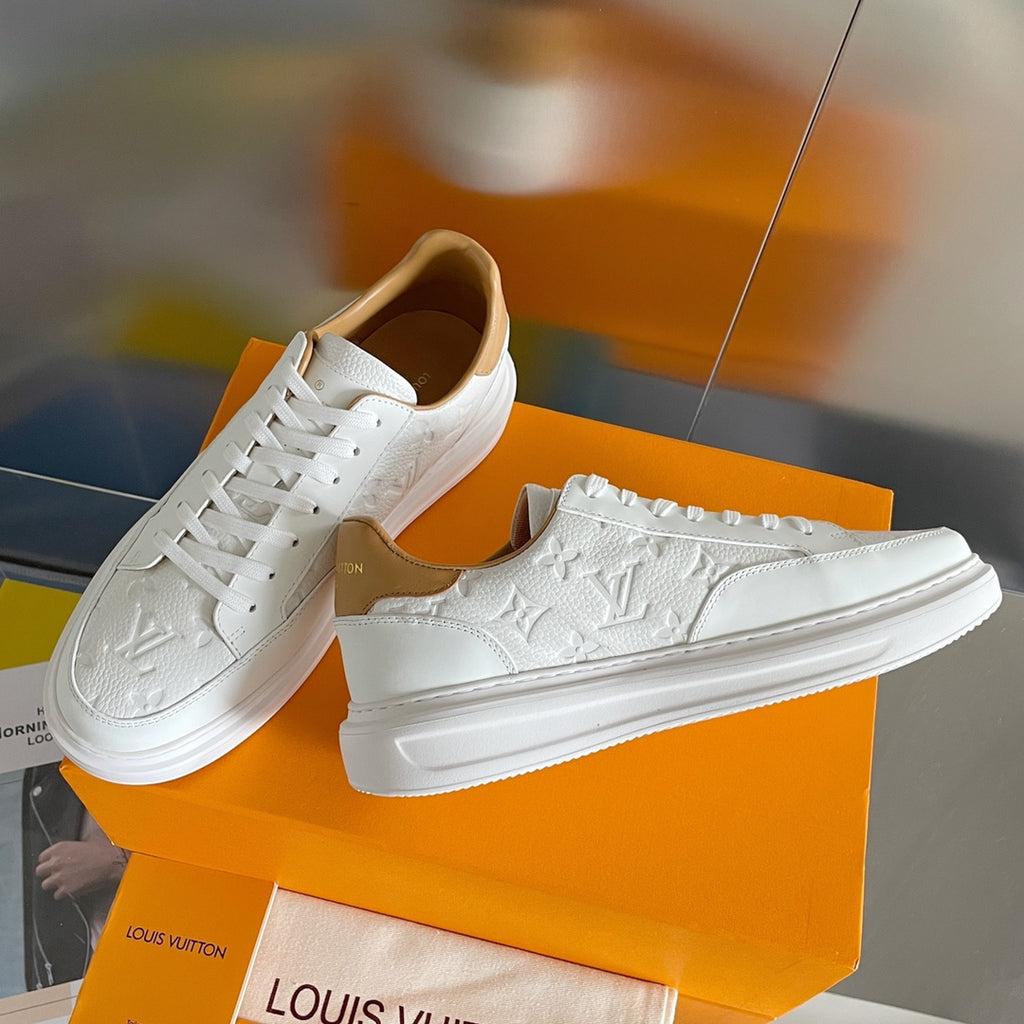 Louis Vuitton white leather sneakers, three-quarter view on orange shoebox