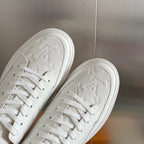 Louis Vuitton white leather sneakers, close-up of laces and embossed monogram