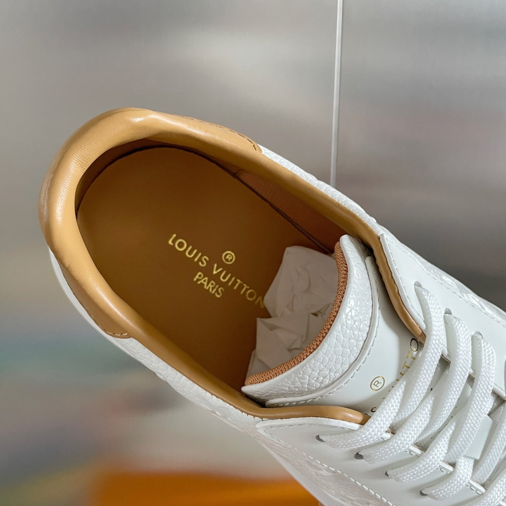 Louis Vuitton white sneaker interior view with tan lining and logo on insole