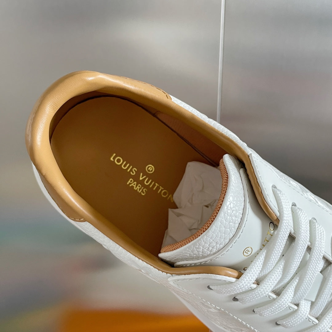 Louis Vuitton white sneaker interior view with tan lining and logo on insole