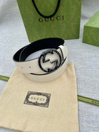 Gucci white leather belt with circular black GG buckle on beige dust bag