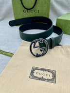 Dark green leather belt with round GG logo buckle, belt looped with buckle centered