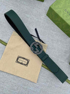Dark green leather belt with round GG logo buckle, strap and buckle in view