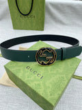 Dark green leather belt with round GG logo buckle, gold-tone edges and dark enamel