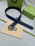 Navy blue leather belt with round double-G logo buckle, angled view