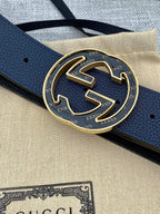 Close-up of navy blue leather belt and round double-G buckle