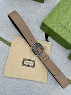 Tan leather belt with round GG logo buckle on end and punched sizing holes