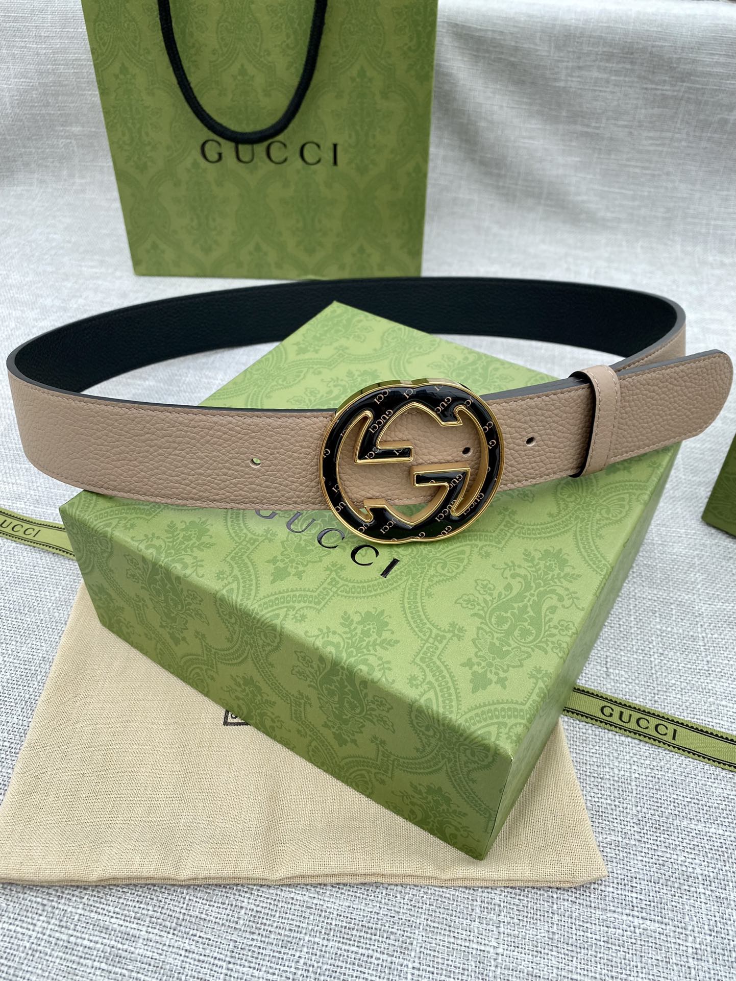 Tan leather belt with round GG logo buckle in gold-tone and dark detailing