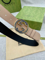 Tan leather belt with large round GG buckle and adjustable holes