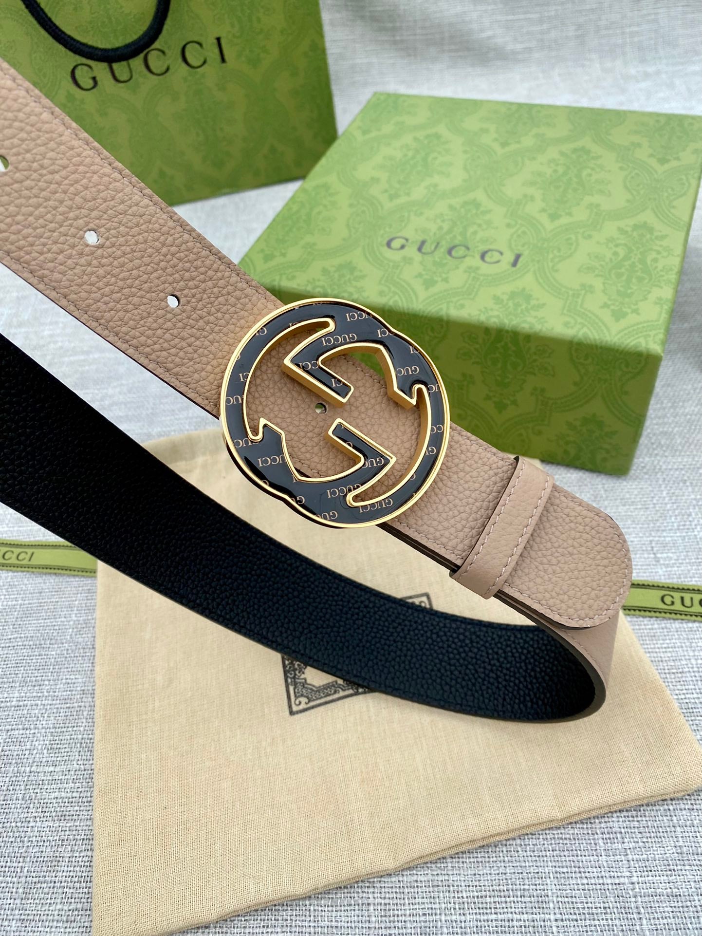 Tan leather belt with large round GG buckle and adjustable holes
