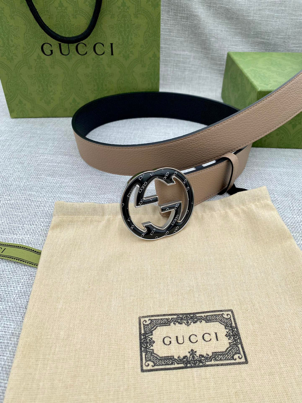 Tan leather belt with round GG logo buckle on light strap