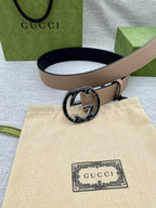 Tan leather belt with round GG logo buckle on light strap