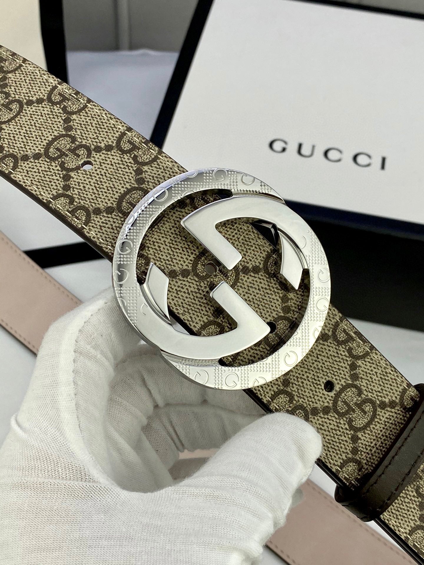 GG canvas belt with silver-tone interlocking G buckle; close-up of buckle detail.