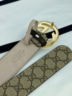 GG canvas belt with gold-tone metal buckle and beige keeper strap; close-up hardware.