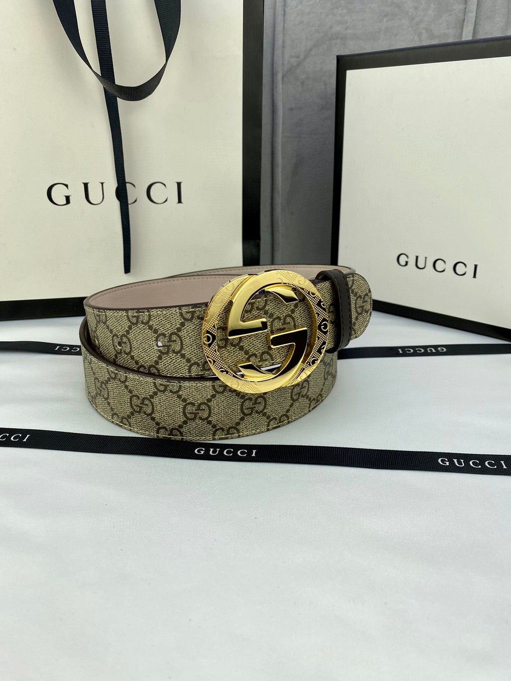 GG canvas belt with gold-tone double G buckle, wide strap in dark brown monogram pattern.
