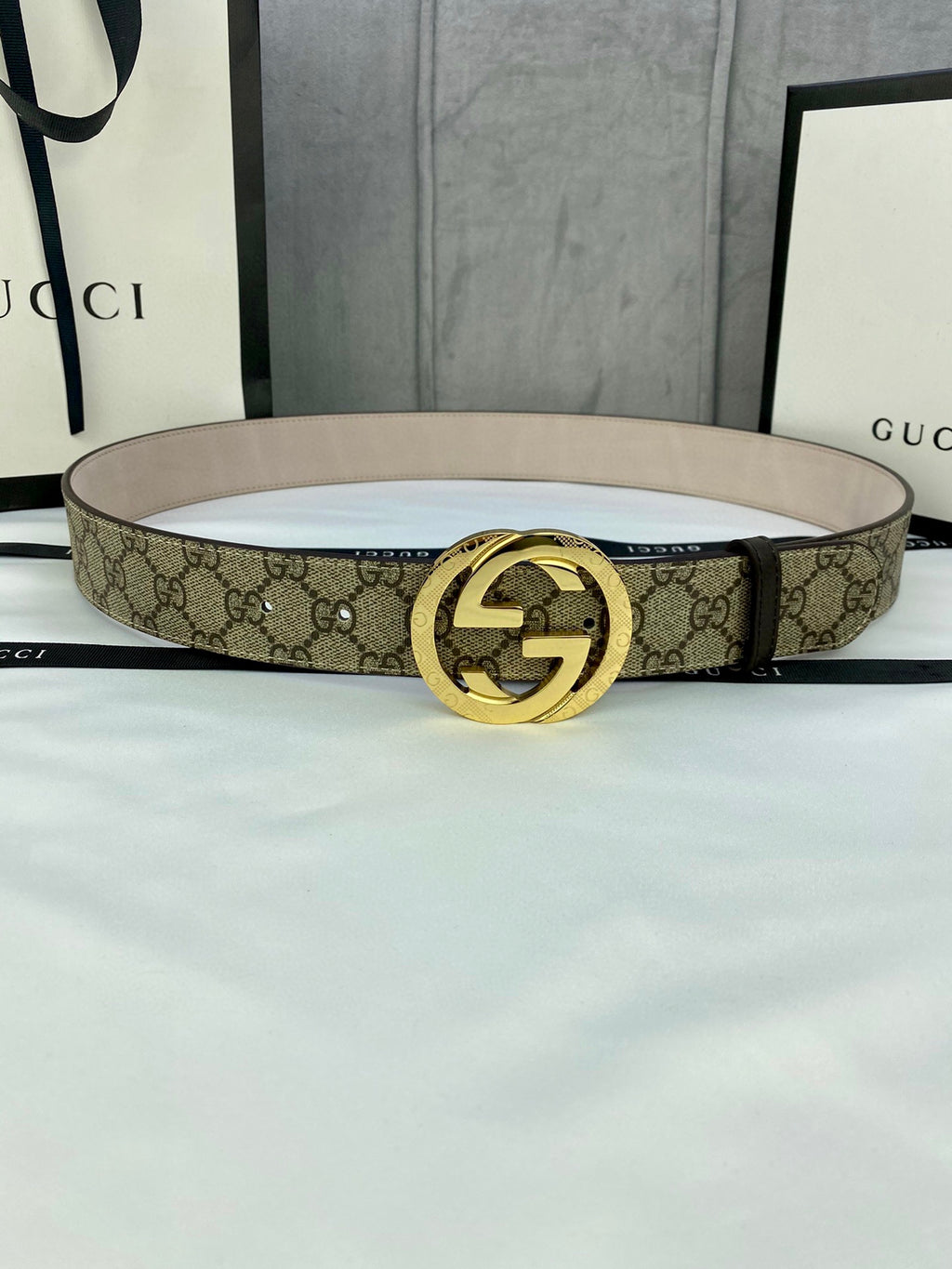 Gucci GG canvas belt with gold-tone double G buckle, light beige strap and monogram print.