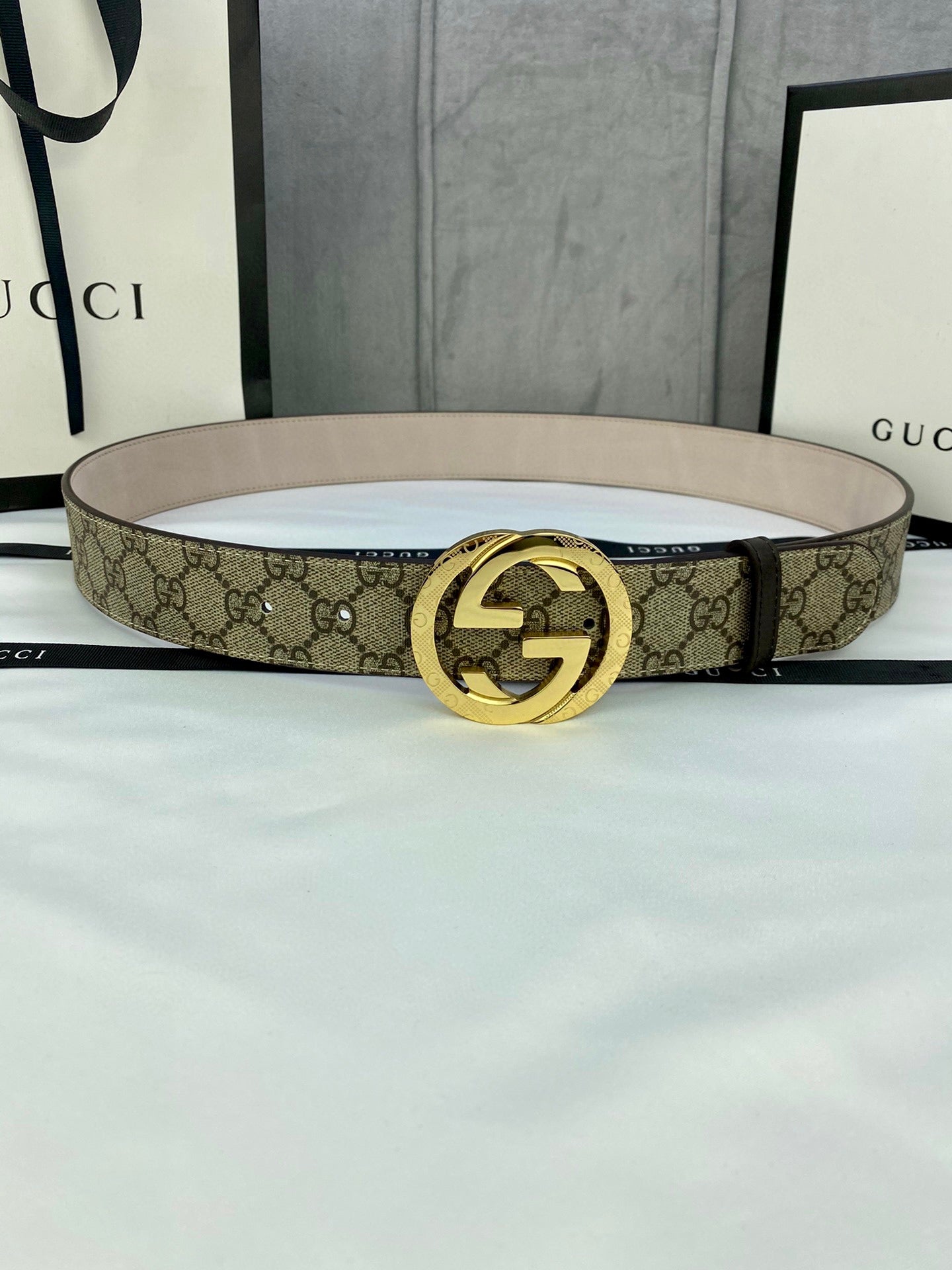 Gucci GG canvas belt with gold-tone double G buckle, light beige strap and monogram print.