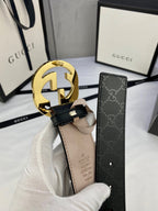 Black monogram leather belt with gold double-G buckle, looped strap