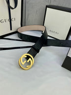 Black monogram leather belt with gold double-G buckle, strap angled