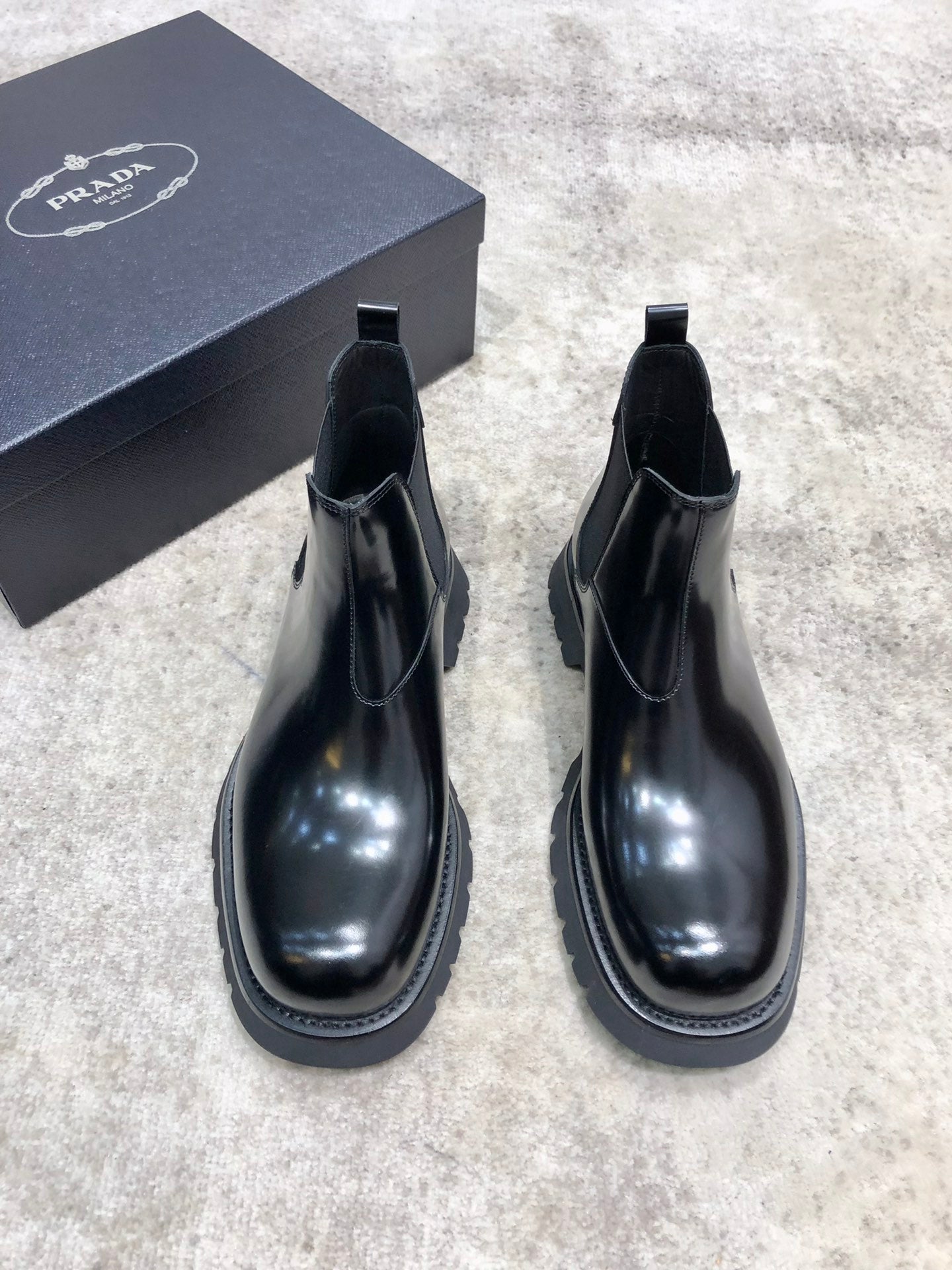 Prada unisex Chelsea boots in dark glossy leather with pull-on elastic and lug sole