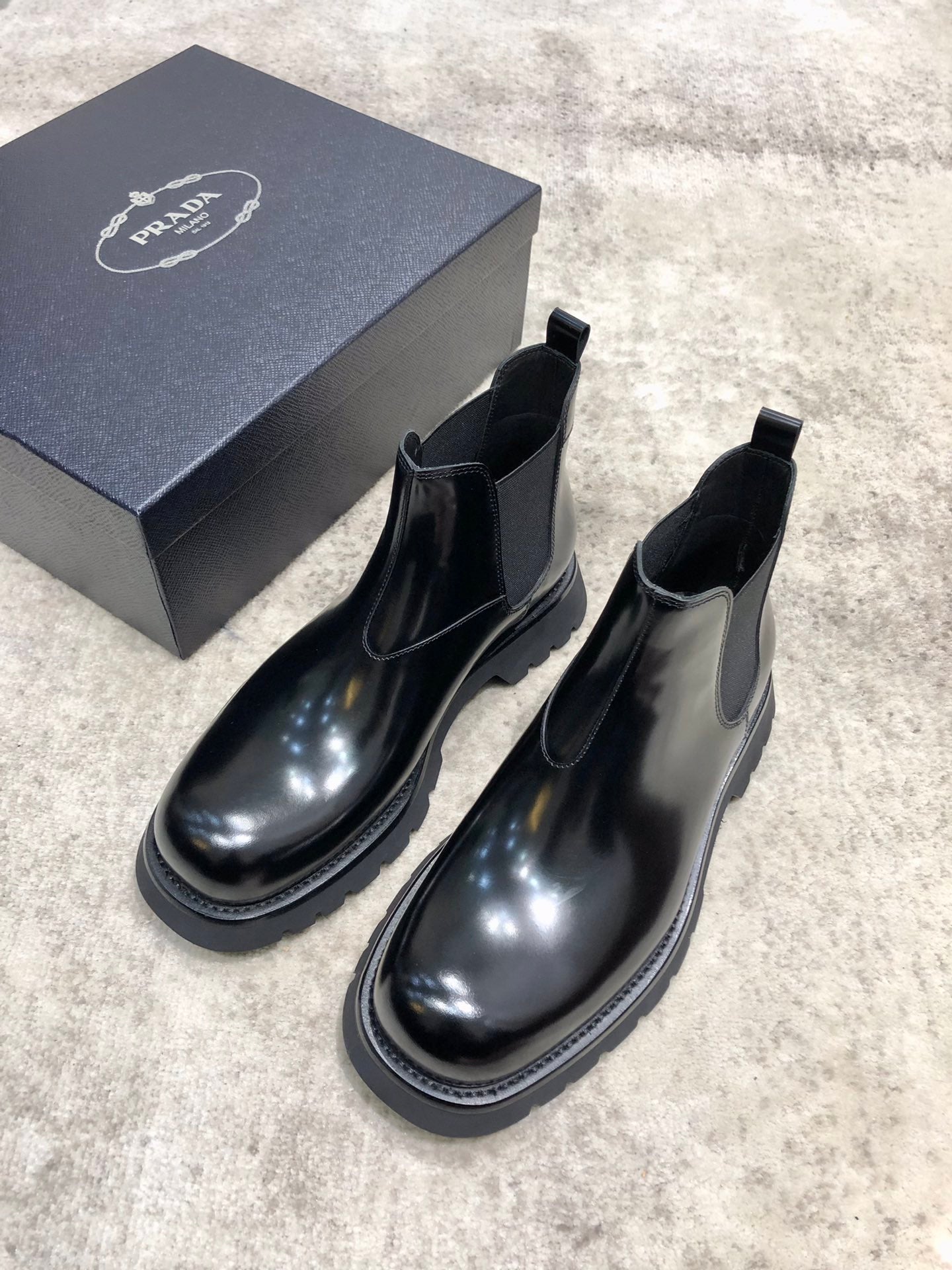 Prada unisex Chelsea boots in dark glossy leather with elastic gore and thick rubber sole