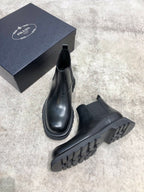 Black leather Chelsea boots with side elastic and lug sole with textured tread