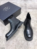 Black leather Chelsea boots with elastic gore and stacked sole, two-angle view