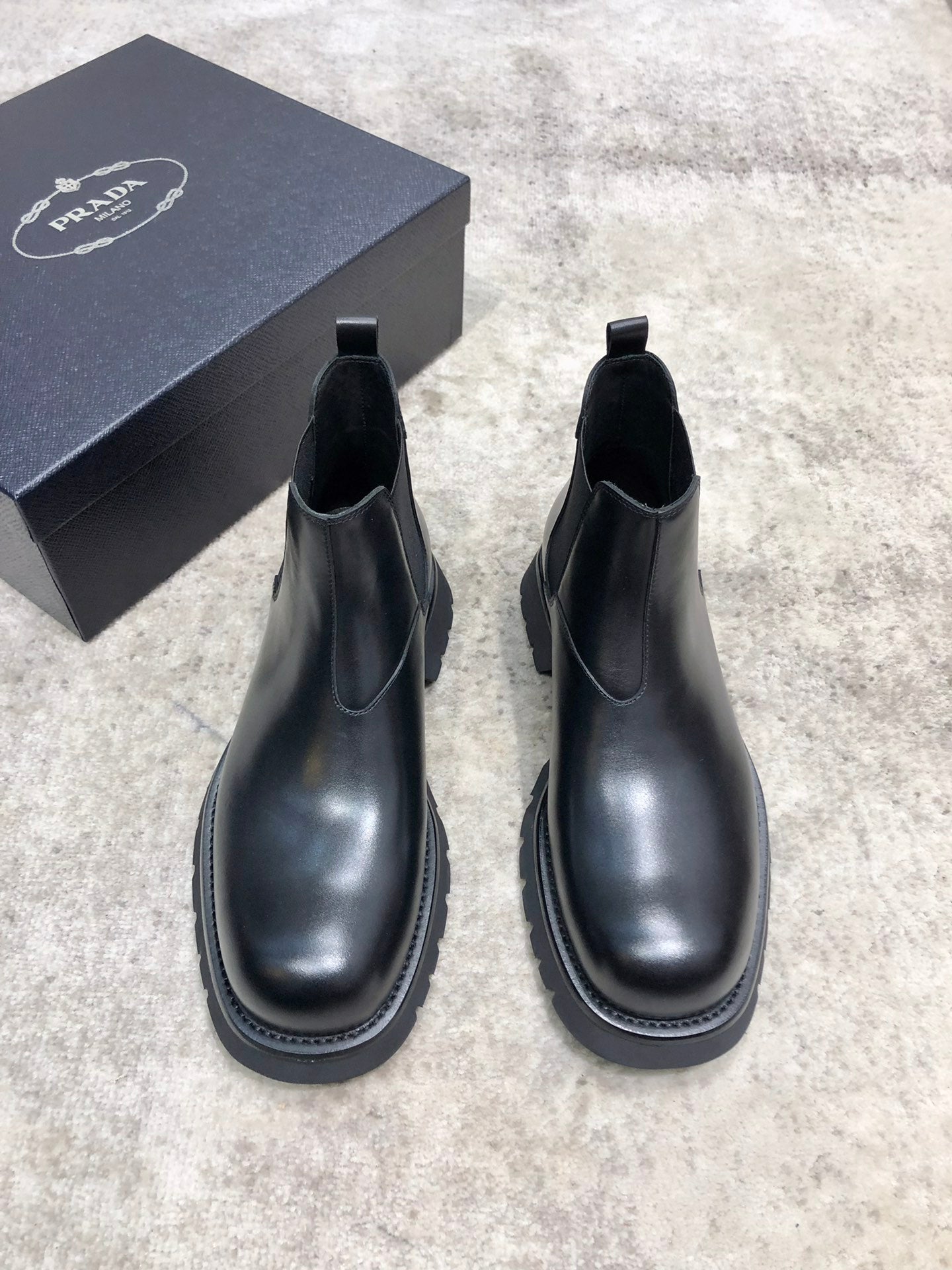Black leather Chelsea boots with elastic side panels and chunky rubber sole