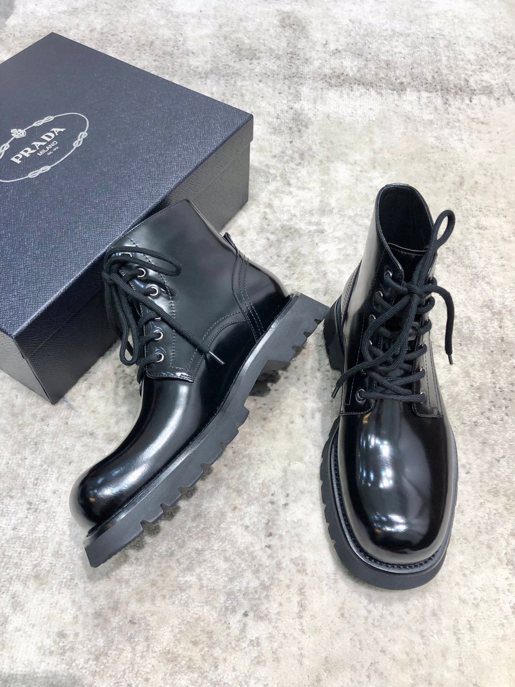 Lace-up leather boots with glossy dark leather, chunky tread sole, lace front