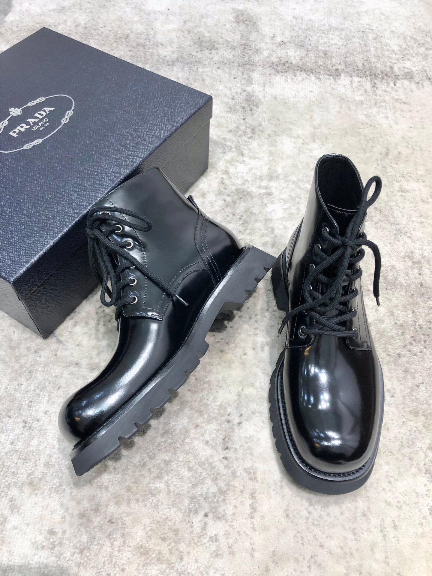 Lace-up leather boots with glossy dark leather, chunky tread sole, lace front