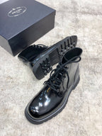 Lace-up leather boots with treaded rubber sole, glossy dark uppers, lace closure